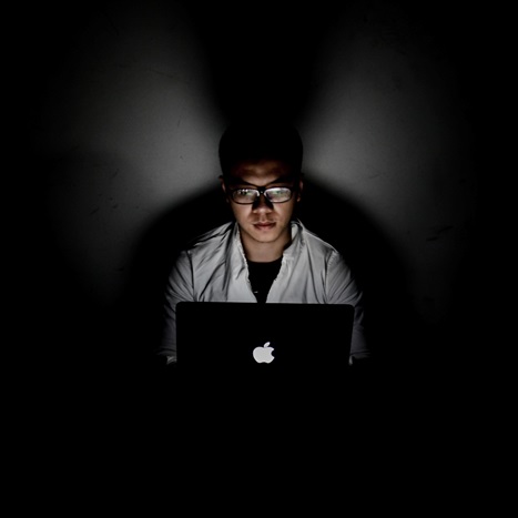 an individual using laptop while wearing anti-blue light glasses